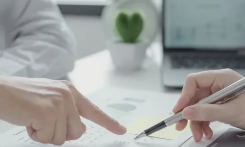 One-to-one personal coaching session showing hands pointing at business strategy documents during a focused career development consultation